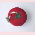 Vintage tomato shaped pincushion and tape measure.