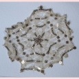 A large vintage lace motif with silver spangles.